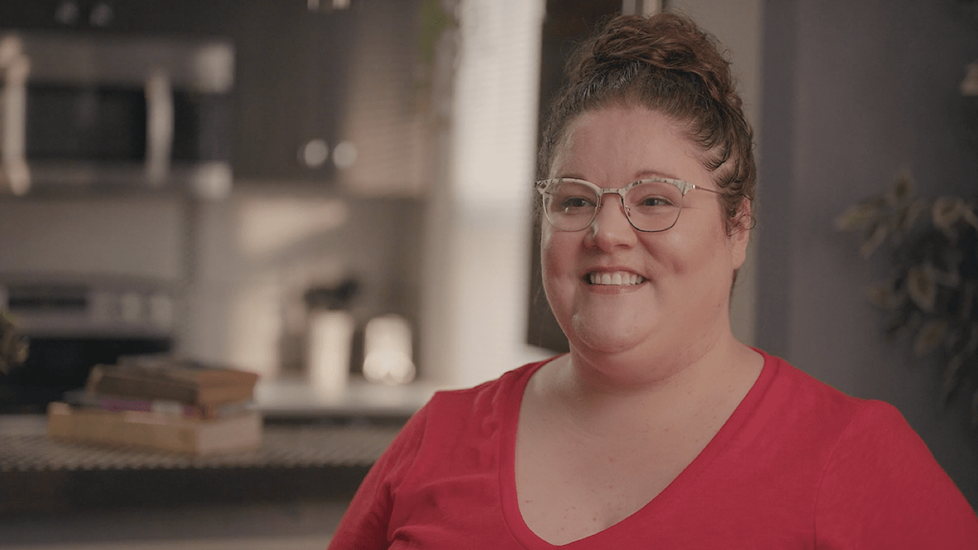 A woman sitting in a chair talking to a camera
